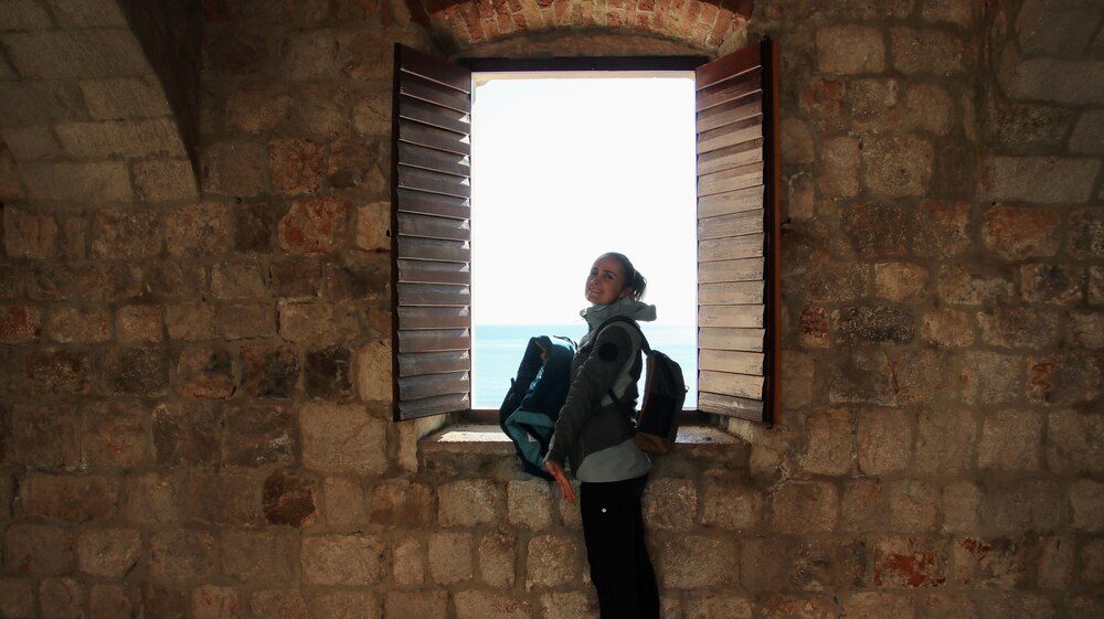 Woman looking out of a window in a Fort.